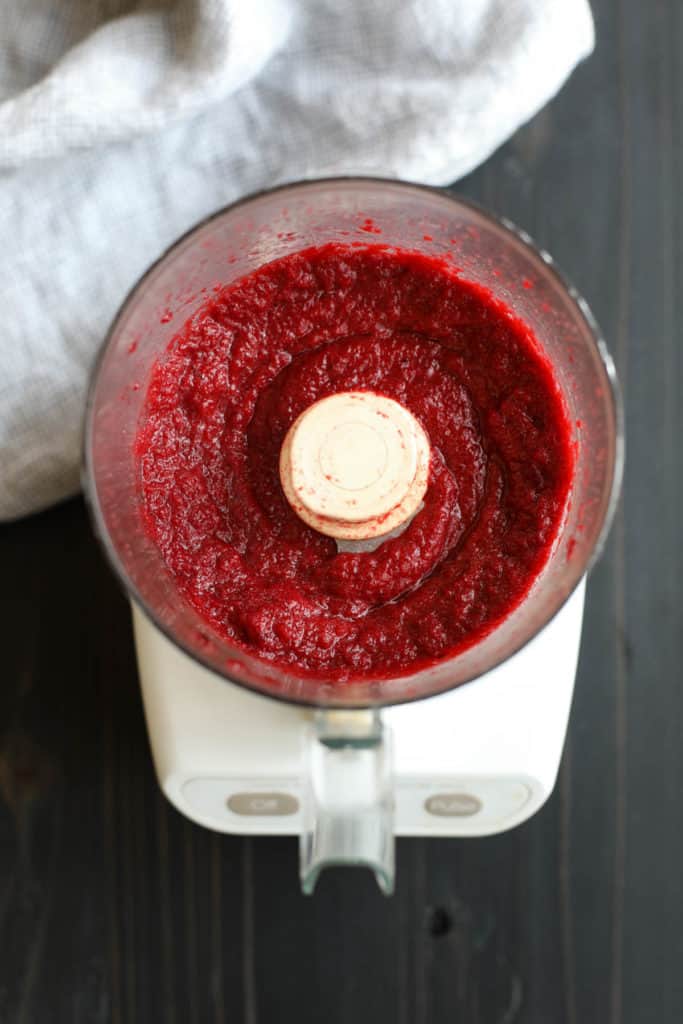 Overhead view of a food processor filled with blended beets