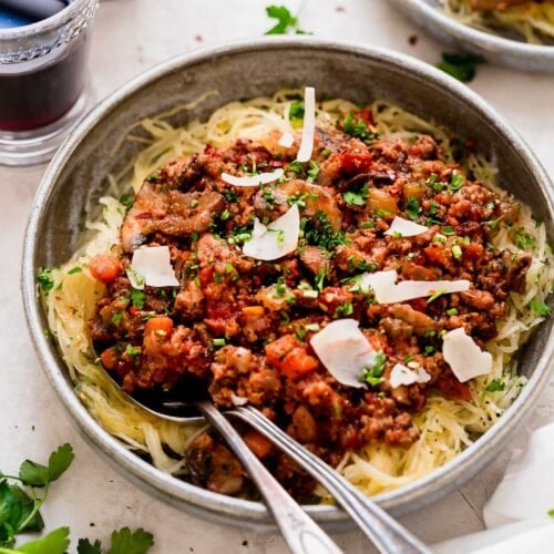 Overhead view turkey mushroom bolognese served over spaghetti squash strands in stone bowl