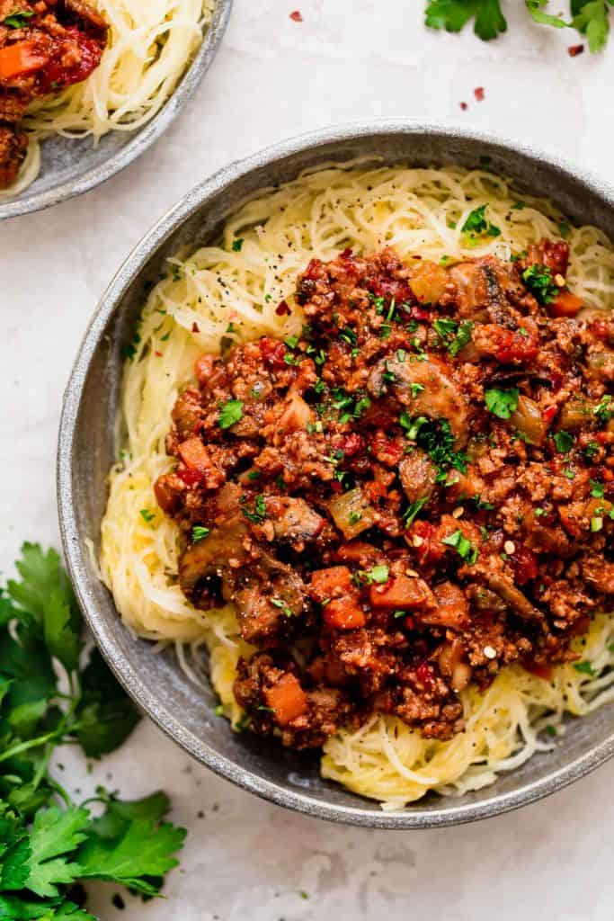 Overhead view of a plate of Instant Pot Turkey Mushroom Bolognese topped with fresh herbs