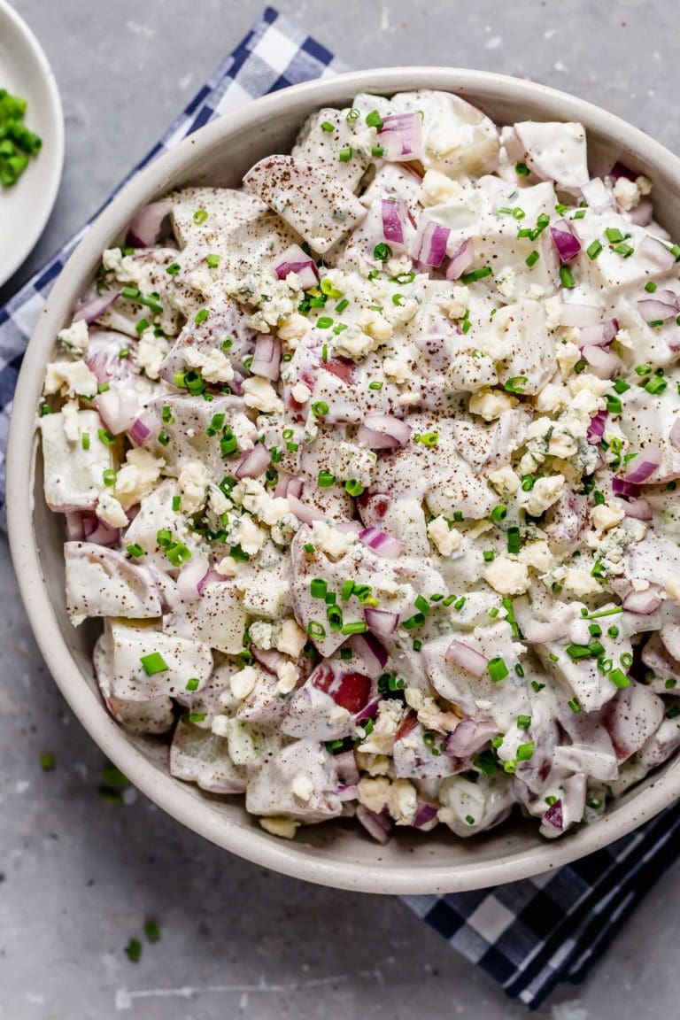 Overhead view potato salad with blue cheese sauce topped with chives
