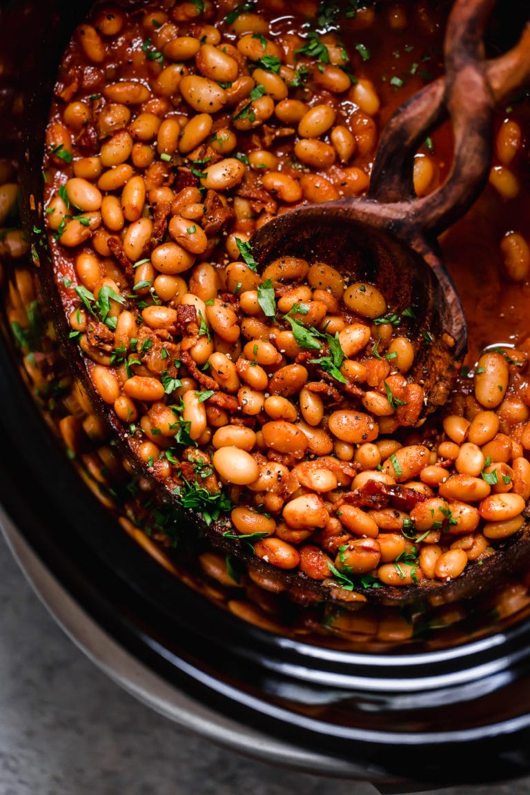 Overhead view of a slow cooker filled with baked beans. 