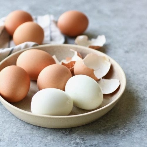A bowl of Hard-Boiled Eggs and eggshells on a countertop