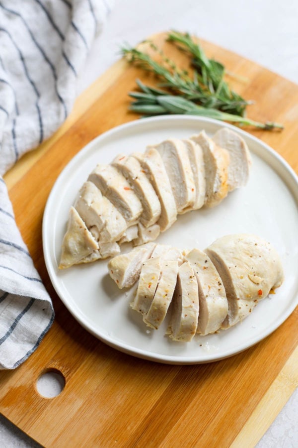 A white plate with 2 cut chicken breasts