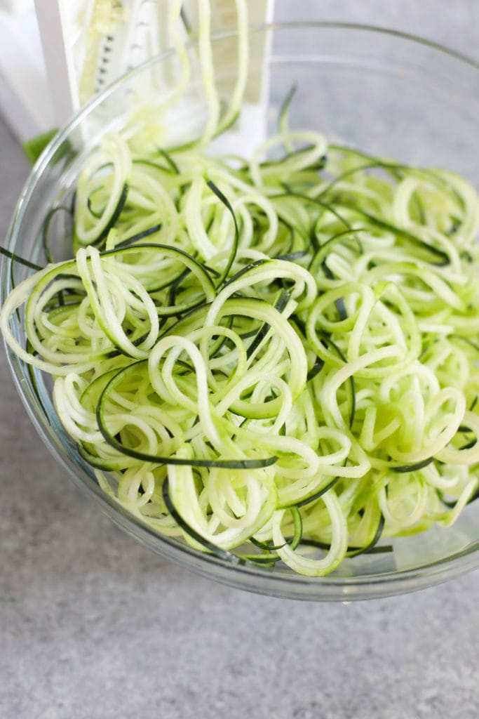Close up view of a glass bowl filled with zucchini noodles