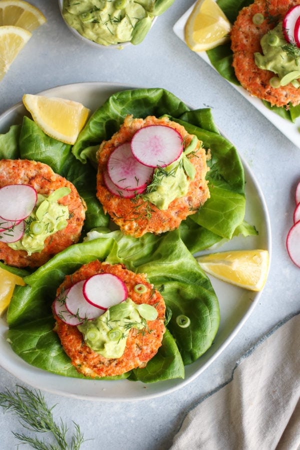 Overhead view of Salmon Burgers with Avocado-Garlic Sauce on a plate. Photo is linked to the recipe.