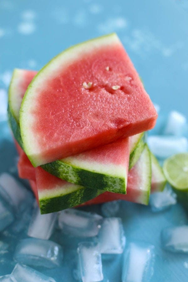 A stack of sliced watermelon pieces on a blue countertop