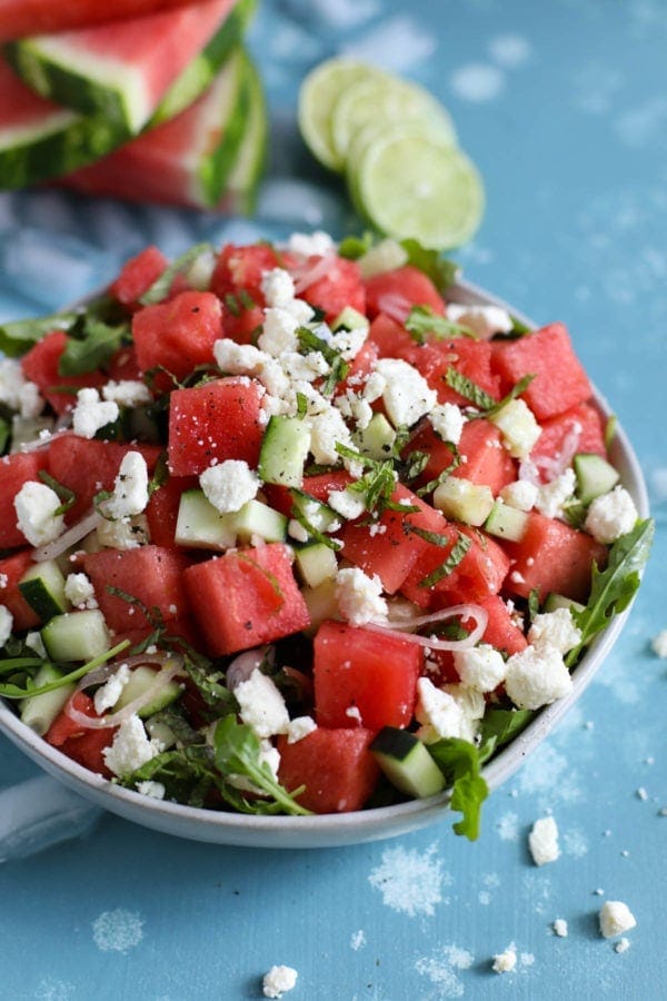 Close up view of a bowl of Watermelon-Cucumber Salad with Feta topped with fresh mint