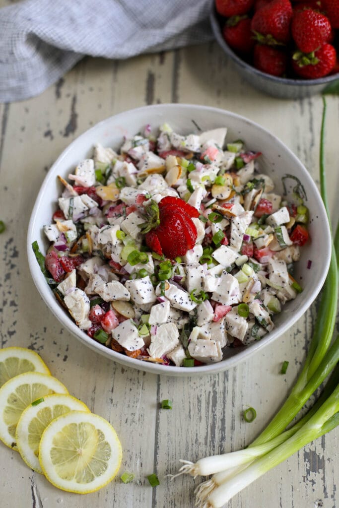 A large white bowl filled with Strawberry Chicken Poppy Seed Salad