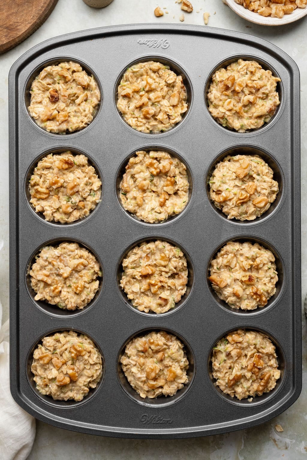 Unbaked oatmeal cups in a muffin pan.