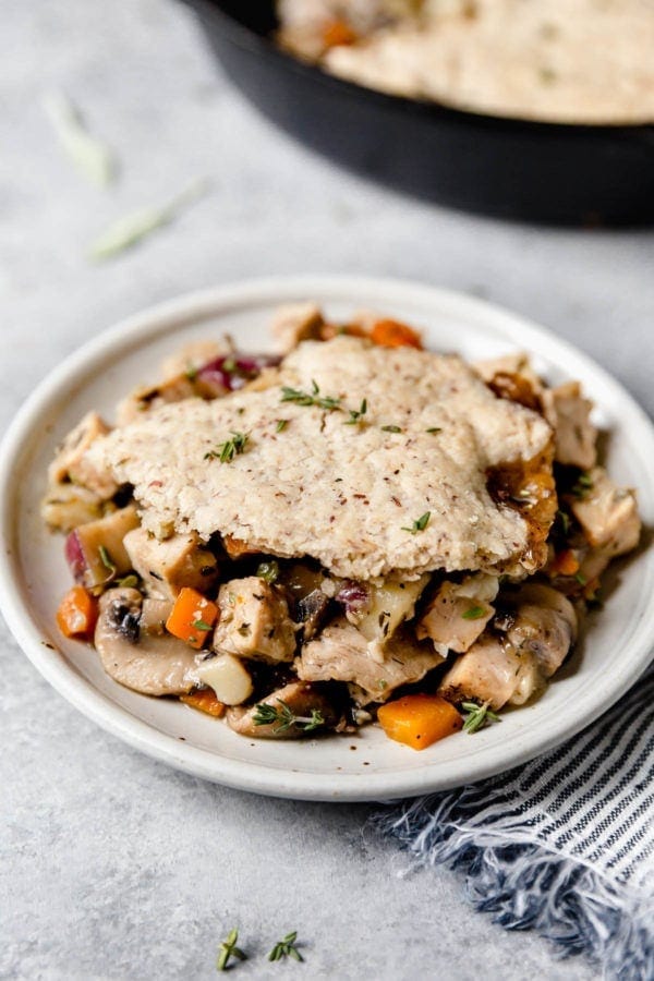A plate of turkey and vegetables in a thyme-sage gravy is topped with a flaky grain-free pastry crust in this Paleo Turkey Pot Pie.