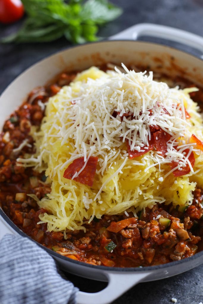Pizza-Stuffed Spaghetti Squash ingredients in a skillet topped with cheese