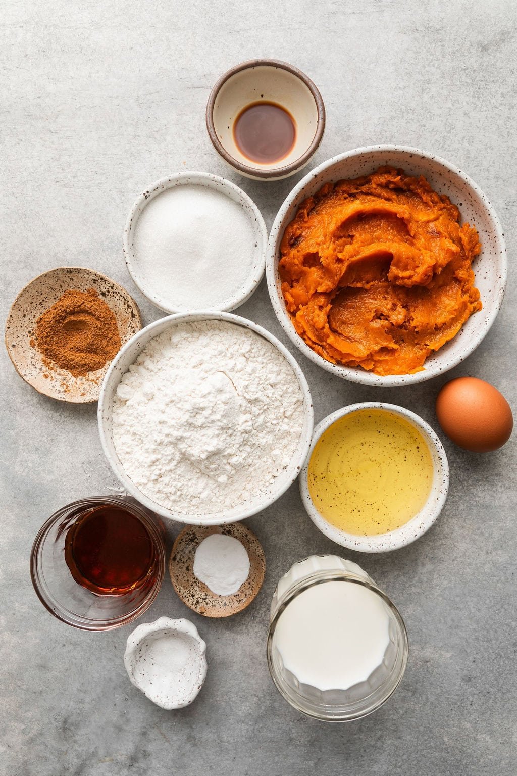 Overhead view of a variety of ingredients for Sweet Potato Muffins in different sized bowls.