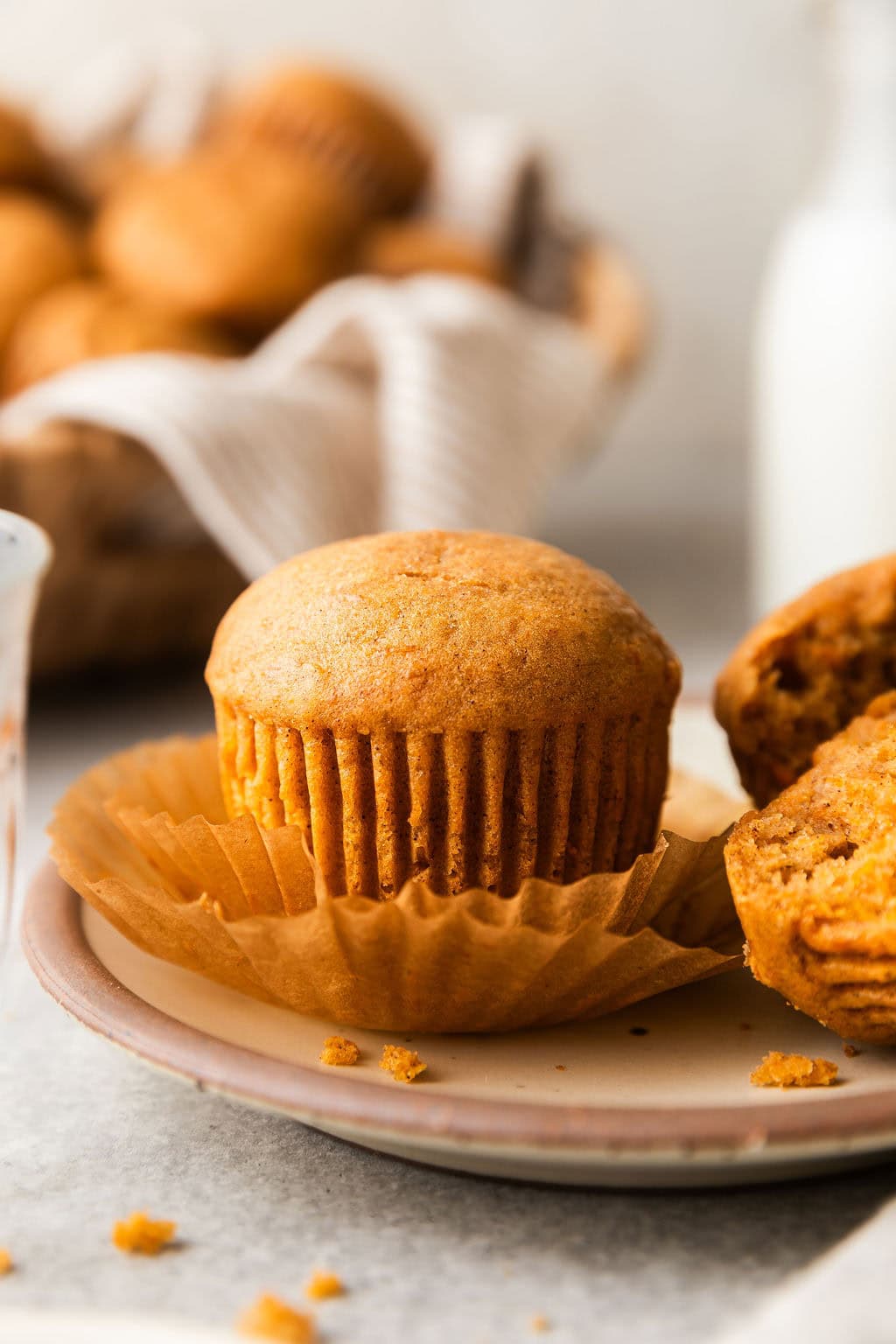 Close up view of a freshly baked Sweet Potato Muffin with the muffin liner peeled back.