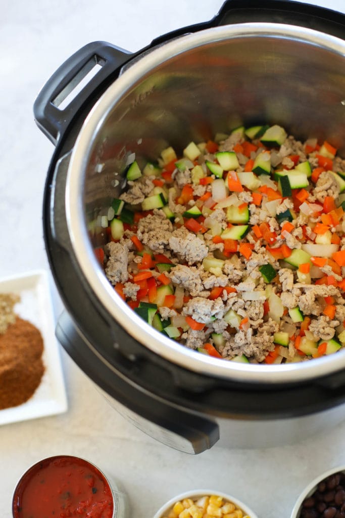 Overhead view of an instant pot filled with turkey chili ingredients