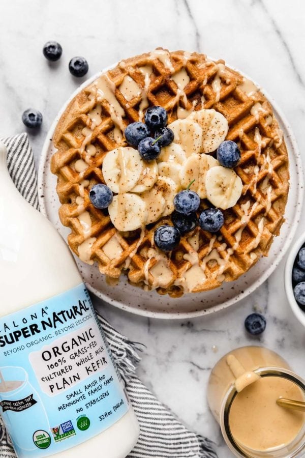Gluten-Free Peanut Butter Banana Waffles on a white plate topped with blueberries