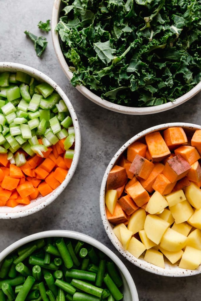 Ingredients for Slow Cooker Healthy Hamburger Soup arranged in white bowls
