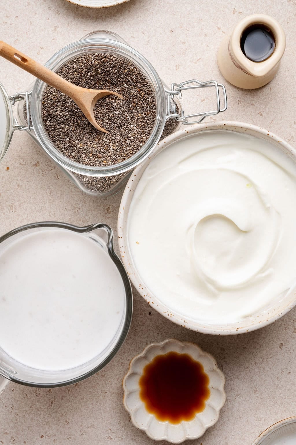 Overhead view of a variety of ingredients for Chia Pudding in different sized bowls. 