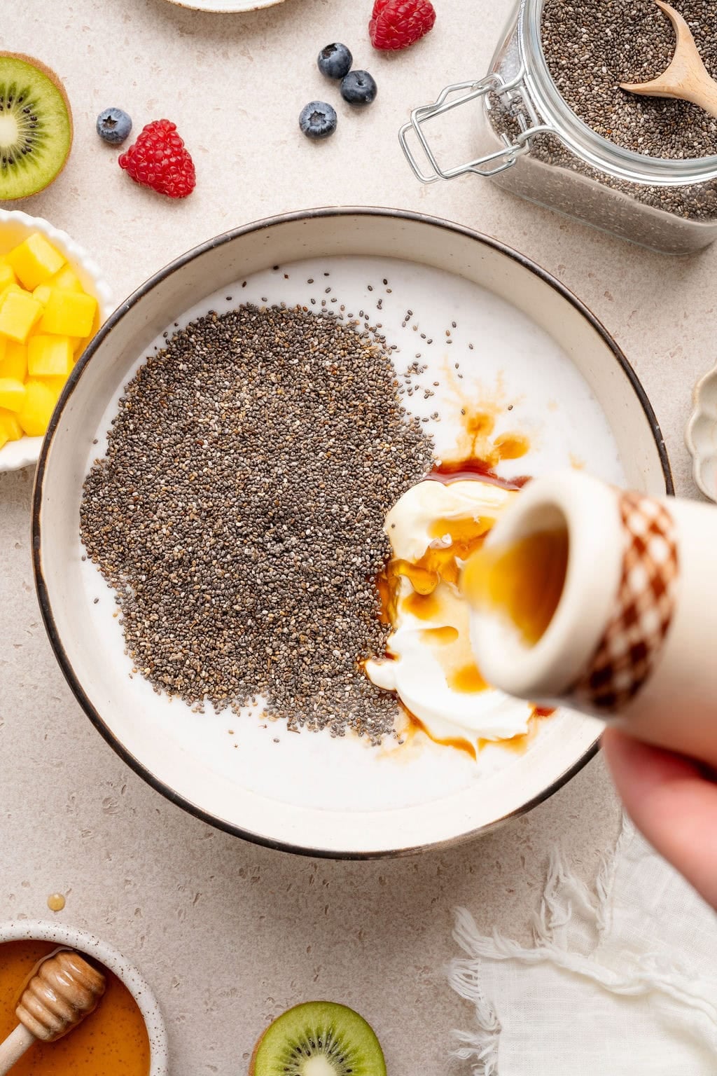 Overhead view of a bowl filled with chia pudding ingredients ready for stirring. 