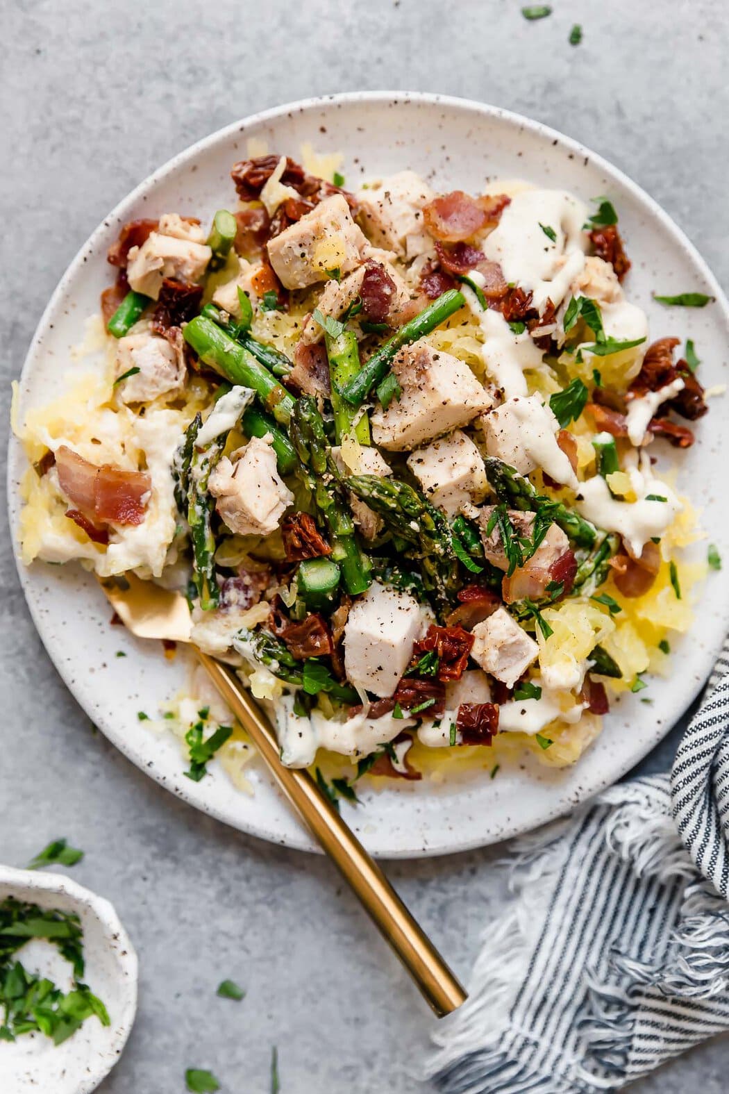 Overhead view of a plate of Creamy Chicken Spaghetti Squash with Bacon and Asparagus