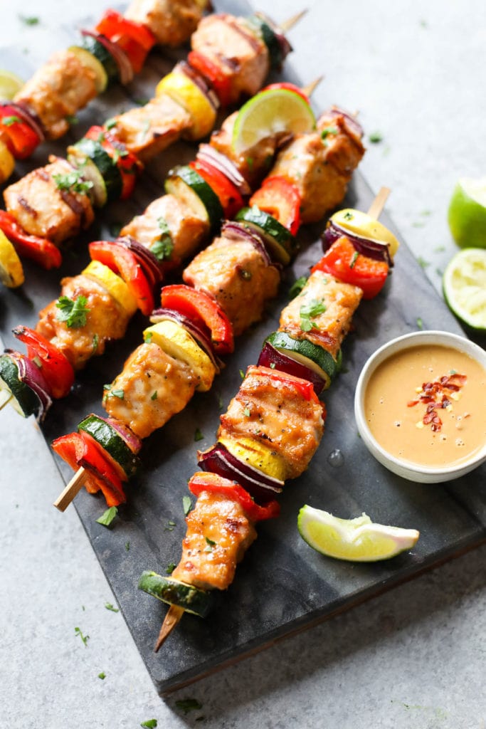 5 Grilled Pork Kebabs with Peanut Sauce and lime wedges