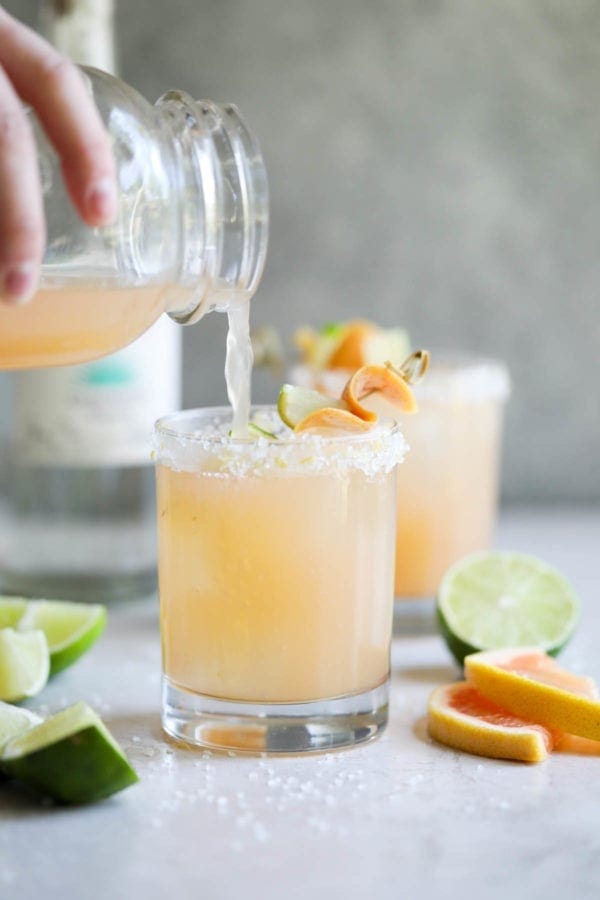 A hand pouring a Low-Sugar Paloma