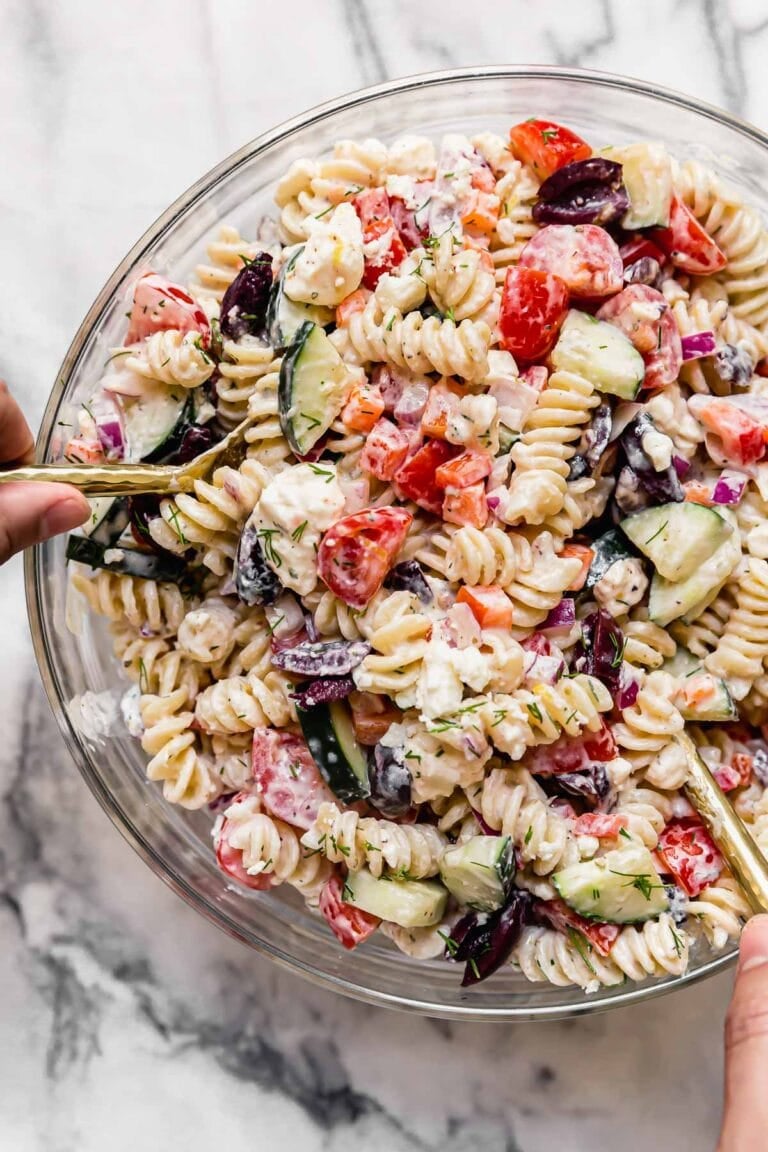 Overhead view of a bowl of Greek veggie pasta salad topped with kalamata olives.