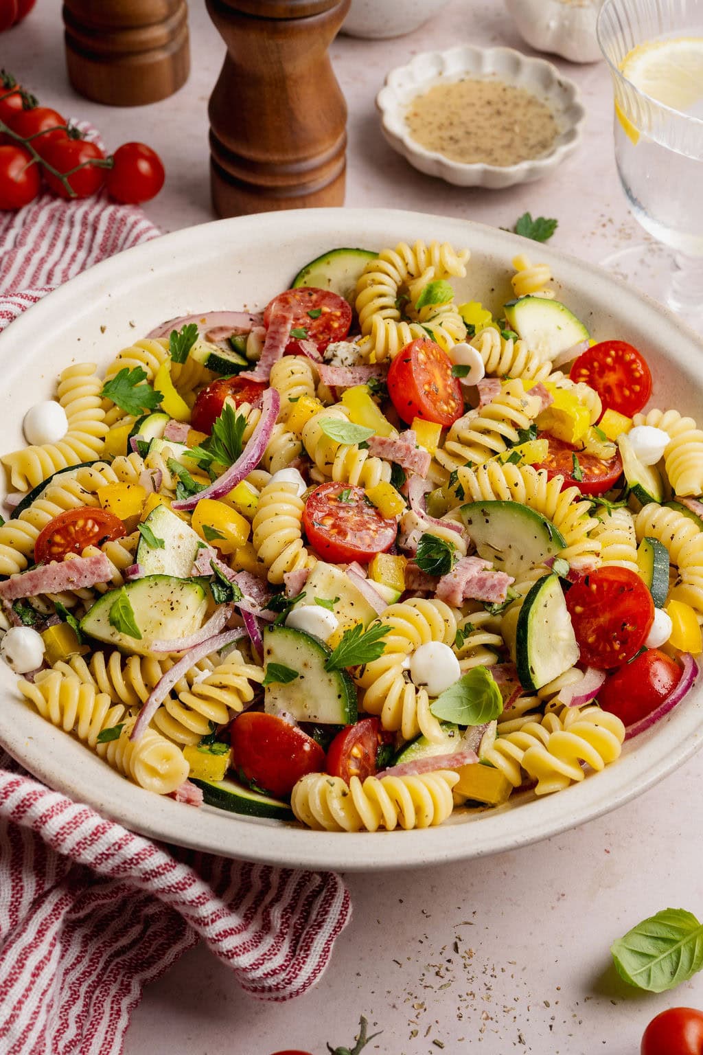 Close up view of a colorful Zesty Italian Pasta Salad topped with fresh herbs and sprinkled with black pepper.