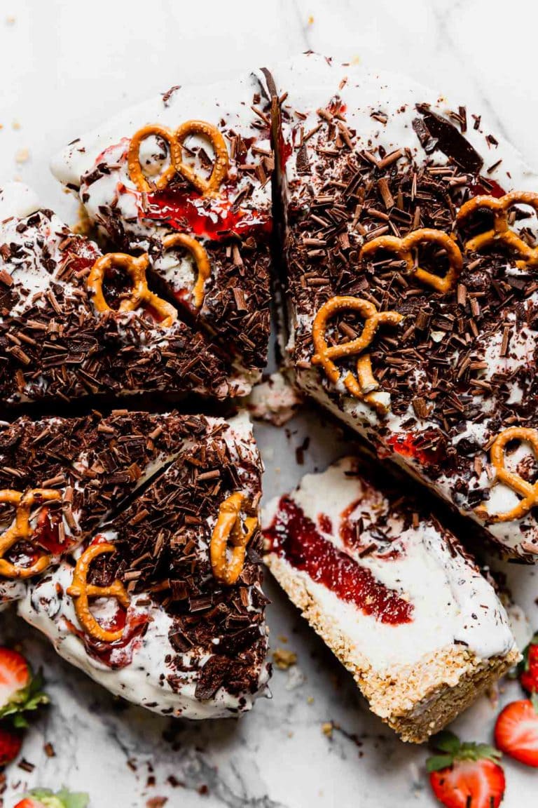 Overhead view of a sliced strawberry pretzel ice cream pie topped with pretzel pieces.