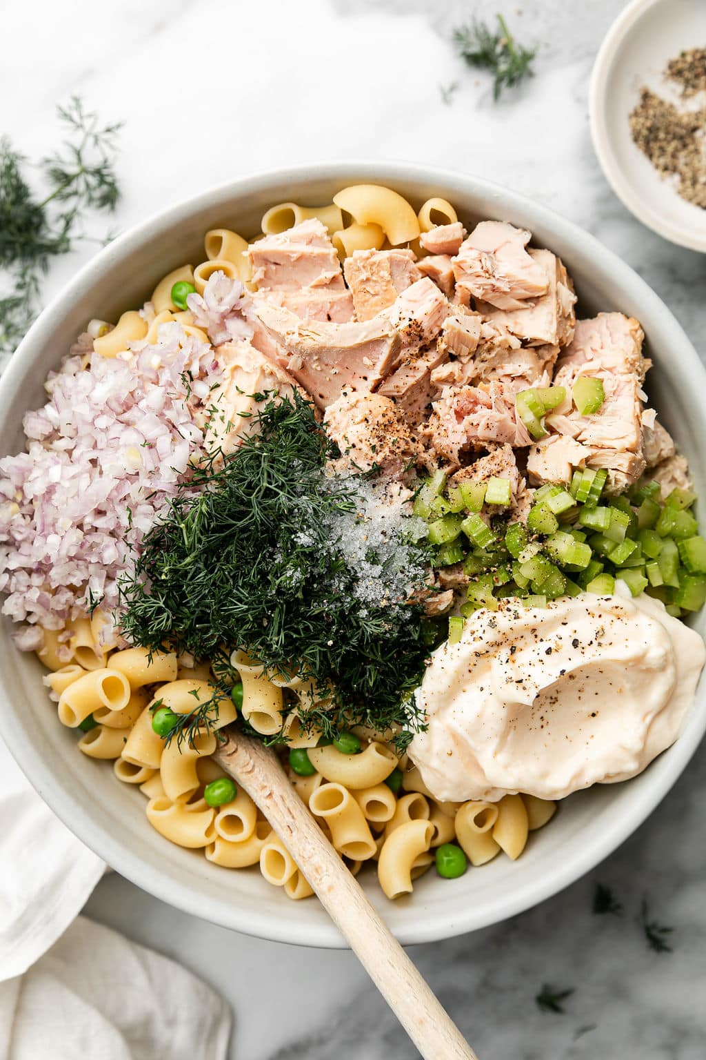 Ingredients for tuna pasta salad in a bowl ready to be mixed together