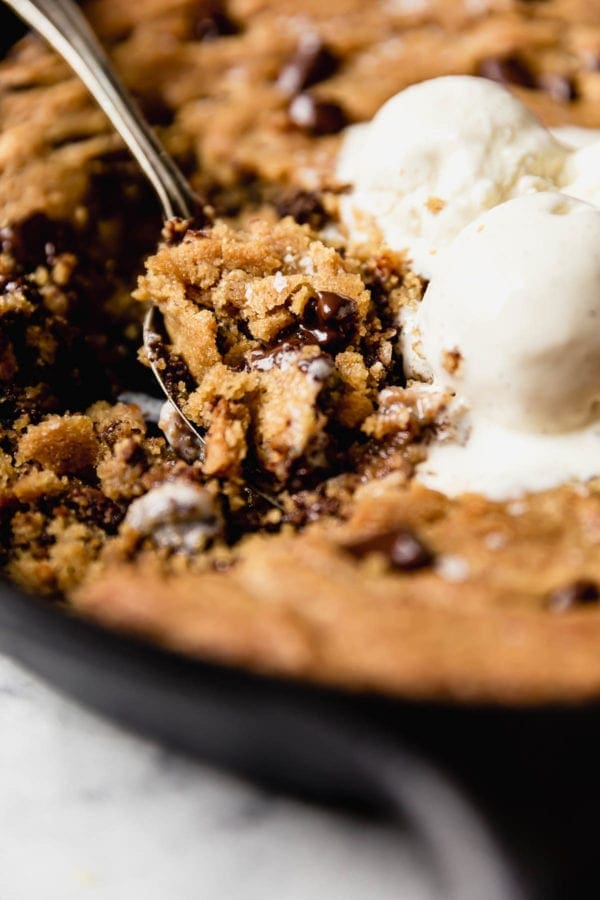 The perfect bite... a big spoonful of soft chocolate chip cookie skillet warm from the oven and topped with slightly melted vanilla ice cream 