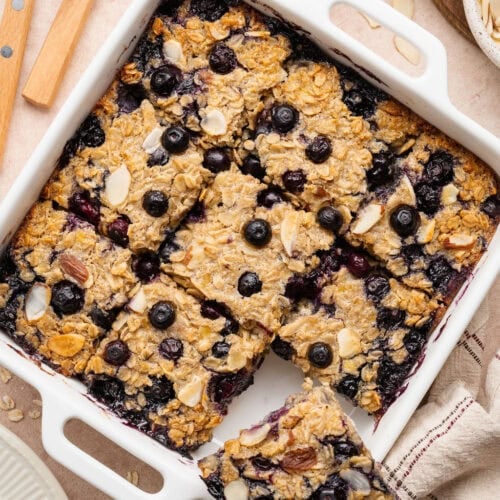 Overhead view of a baking dish filled with blueberry baked oatmeal cut into 9 squares.
