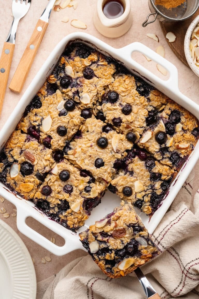 Overhead view of a baking dish filled with blueberry baked oatmeal cut into squares. 