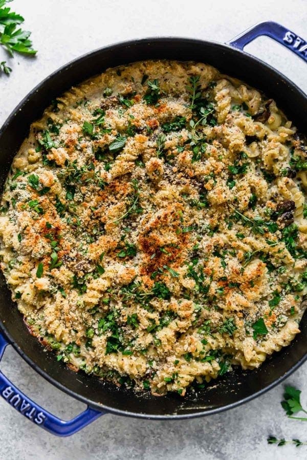 Creamy Tuna Noodle Casserole with a lightly browned breadcrumb topping shown in a cast iron dish. 