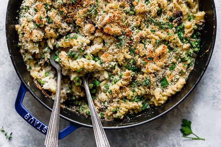 Creamy tuna noodle casserole in skillet with peas.