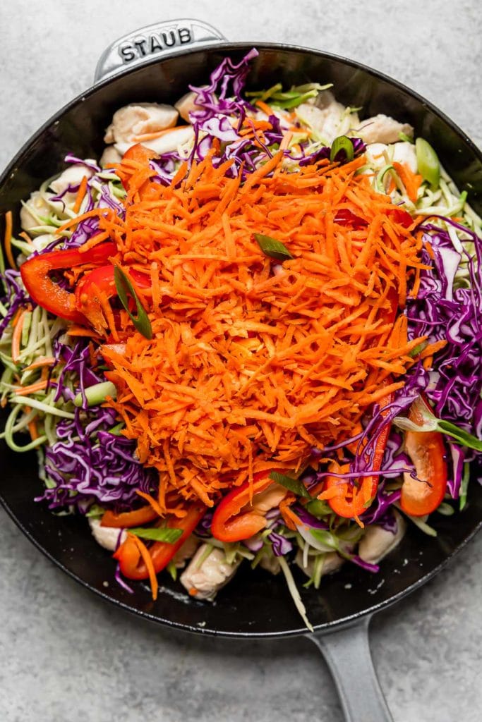 Healthy Chicken Pad Thai ingredients in a large black cast iron skillet.