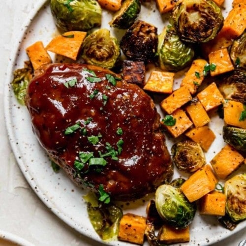 Overhead view stone plate filled with bbq mini meatloaf and roasted vegetables