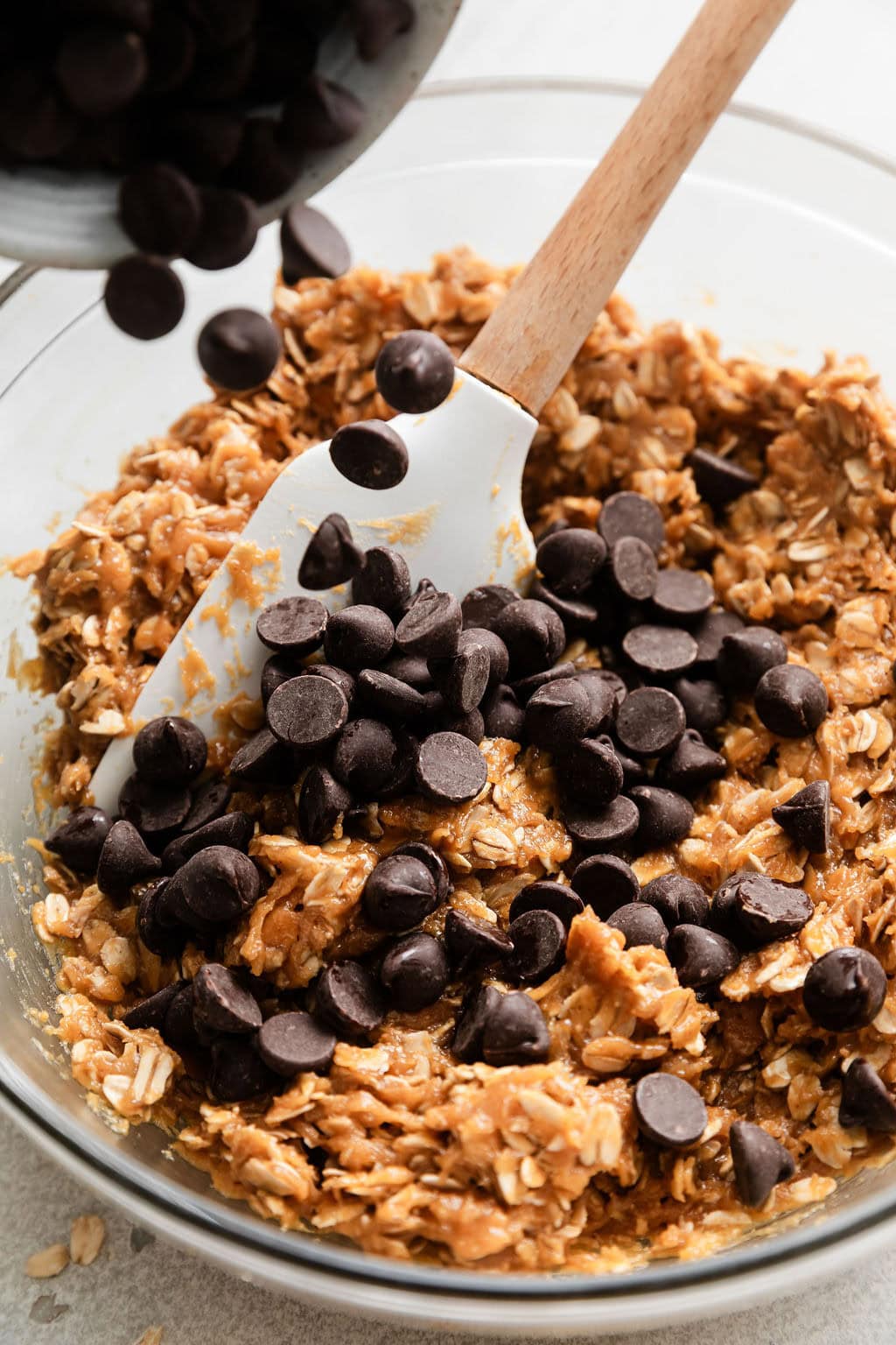 Close up view of a bowl of Peanut Butter Oatmeal Cookie dough topped with chocolate chips on top.