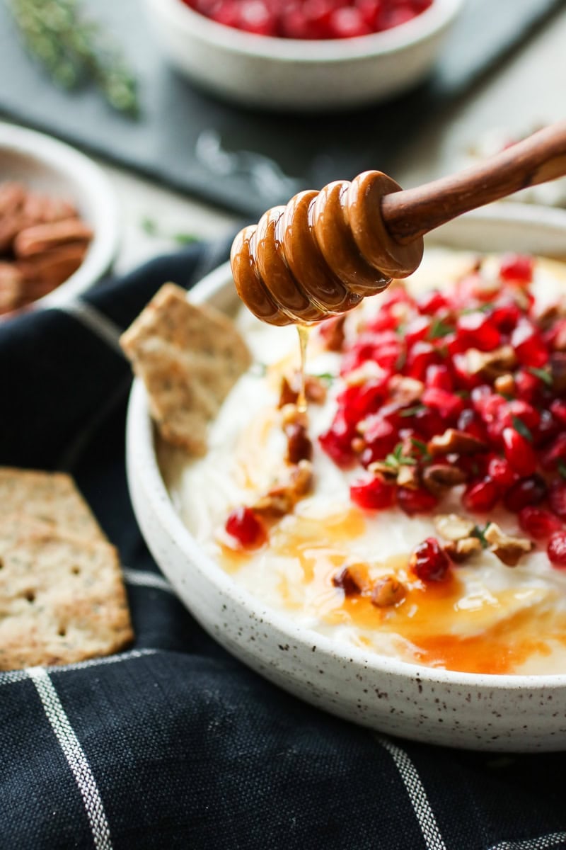 Honey being drizzled over the whipped goat cheese dip.
