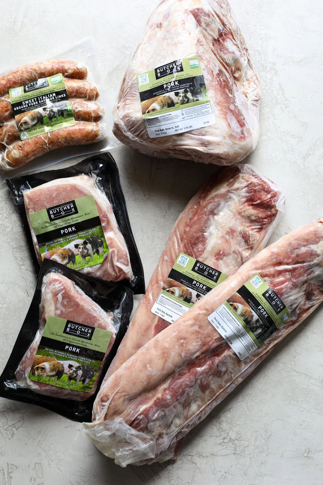 Overhead view of a variety of butcher box pork options including sweet Italian sausage links. 