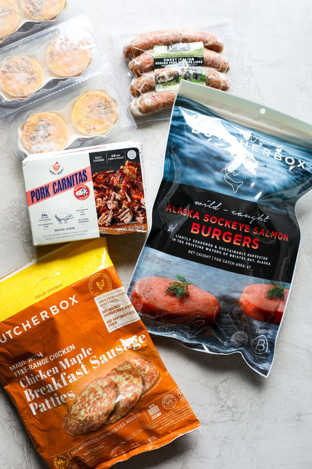 Overhead view of a variety of butcher box meat options including breakfast sausage patties and pork carnitas. 