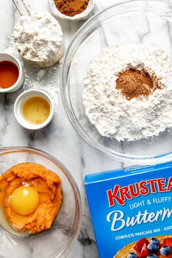All ingredients for fluffy sweet potato pancakes on the counter and some in clear glass bowls ready to be mixed together.