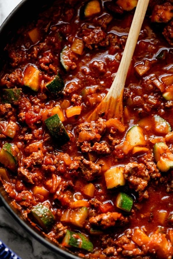 Ground beef, marinara sauce, and vegetables being cooked in a skillet for lasagna skillet