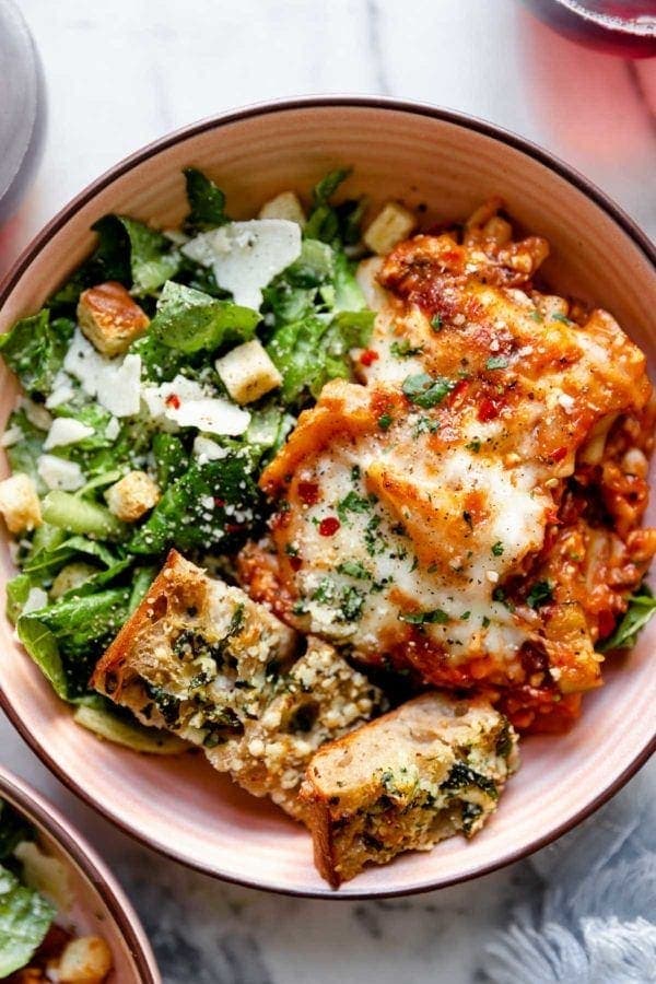 Easy Skillet Lasagna served in a bowl on top of romaine lettuce with shaved parmesan cheese