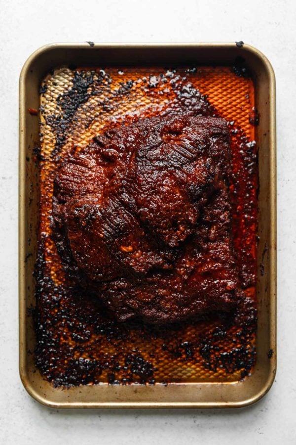 A broil-finished beef brisket on a deep baking sheet