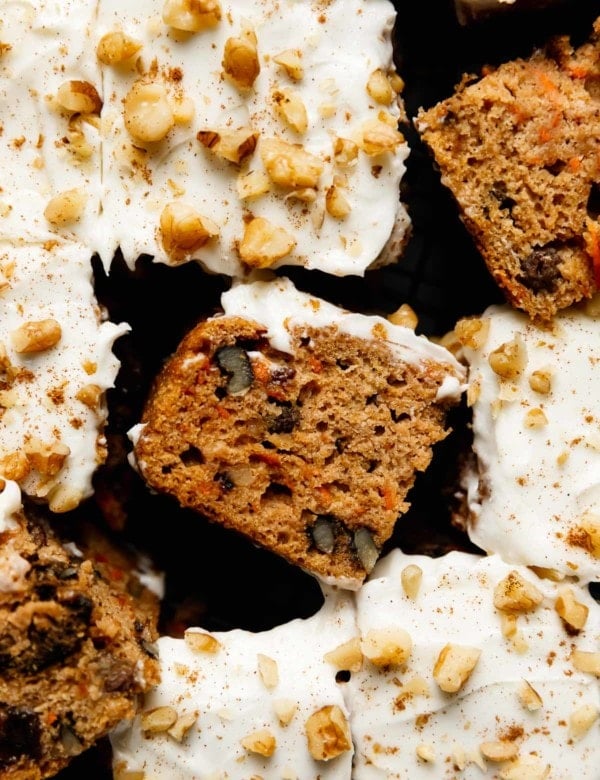Healthy carrot cake bars topped with cream cheese frosting, cut into bars and styled on a cooling rack