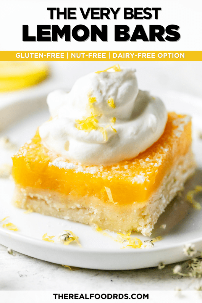 The best lemon bar plated on a white plate topped high with whipped cream and lemon zest