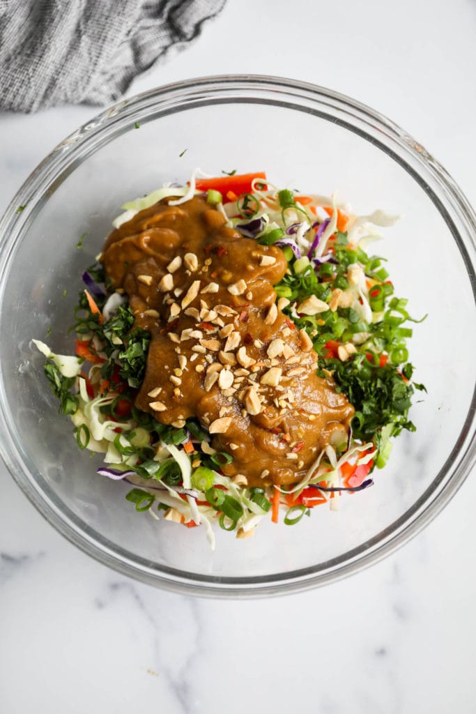 Ingredients for Thai coleslaw in a clear mixing bowl