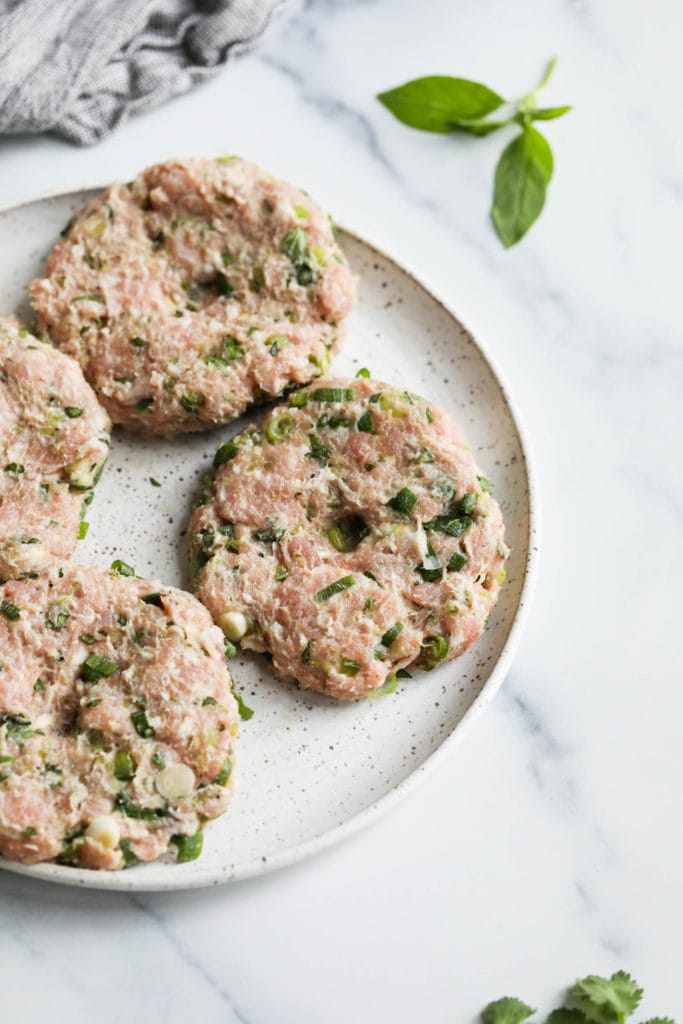 Formed pork burger patties on a plate ready to be grilled