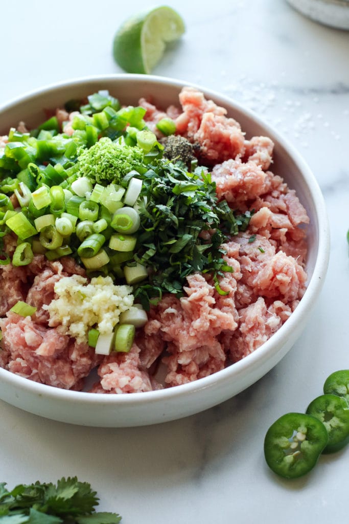 Ingredients for grilled pork burgers in a large bowl