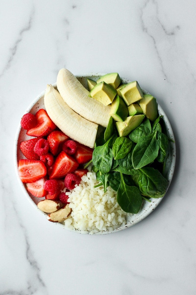 All ingredients for berry blast smoothie packs on a speckled plate